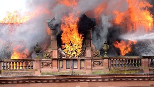 The flames engulf the building's clock 