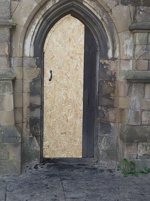 The heavy wooden door to All Saints Church, in Highcross Street, Leicester, was badly damaged in the fire, but not breached