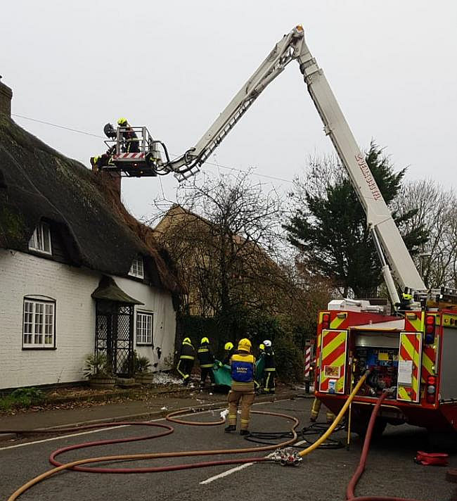 Firefighters try hard to prevent the fire spreading through the thatch of the historic building
