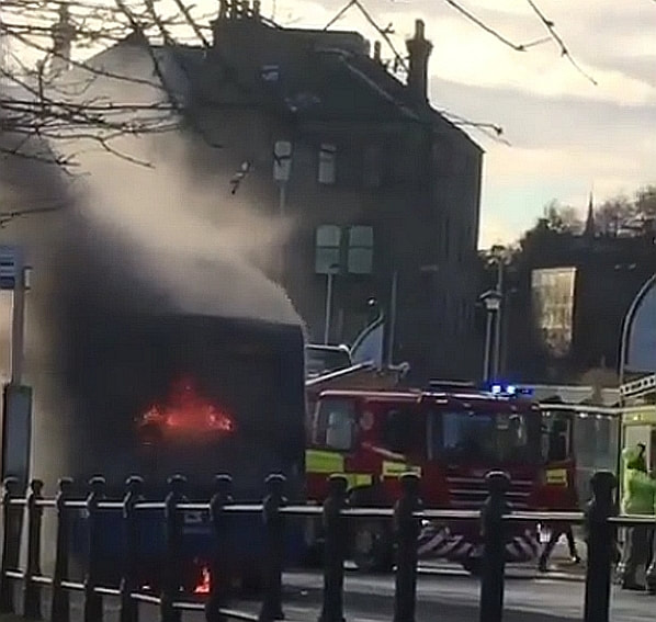 Flames visible at the rear of the bus