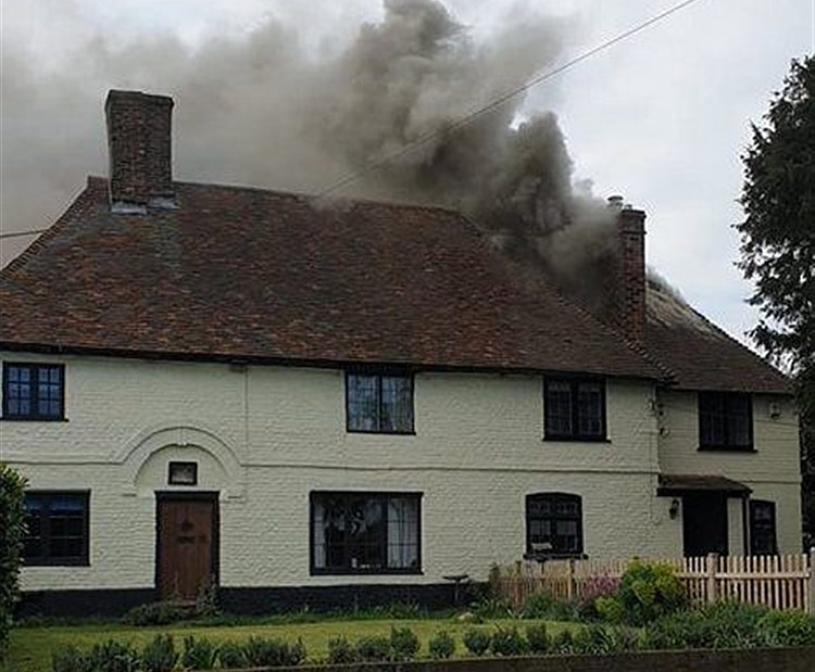 Smoke billows from the 15th century house on fire in Lynsted lane, Lynsted. 