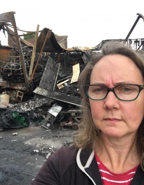 Alison Cosserat in front of the remains of the scrapyard buildings