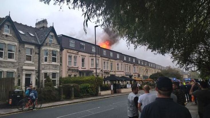 Flames are seen coming from the roof of the hotel (Image: NEC)