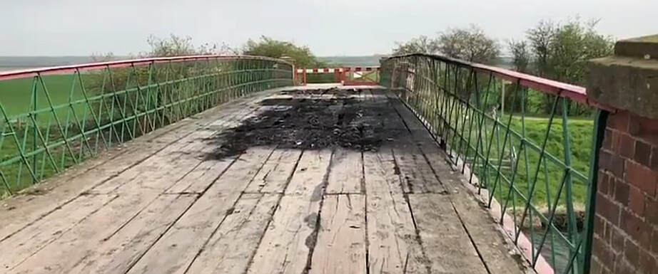 The damage caused to the bridge by the burning vehicles.