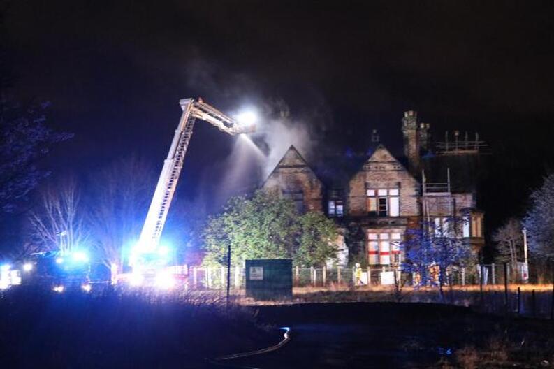 Firefighters tackle to blaze from above. Photo: Richard Garnett