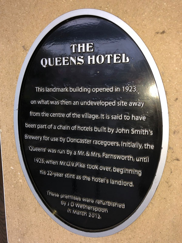 Building History plaque outside The Queens Hotel