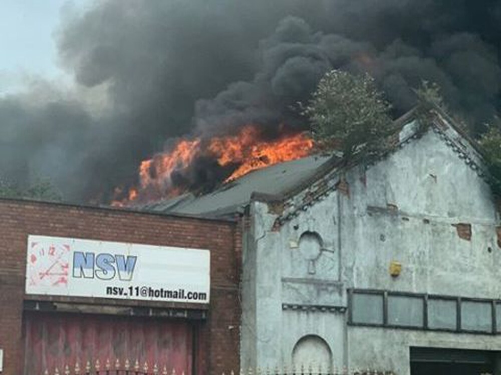Flames burst through the roof of the disused factory, off Rolfe Street, Smethwick. (Picture: Jake Jones)